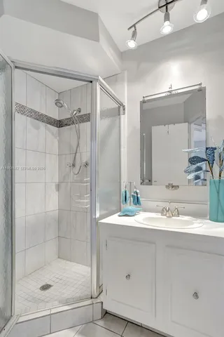a bathroom with a shower sink and mirror