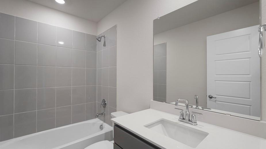 424 Epiphany Lane Lavon, TX 75166 - Photo 18 of 27 Full bathroom featuring a single vanity with a white countertop and undermount sink, chrome faucet, and a large unframed mirror
