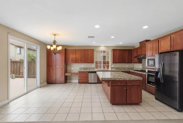 a large kitchen with stainless steel appliances granite countertop a stove a sink and a microwave