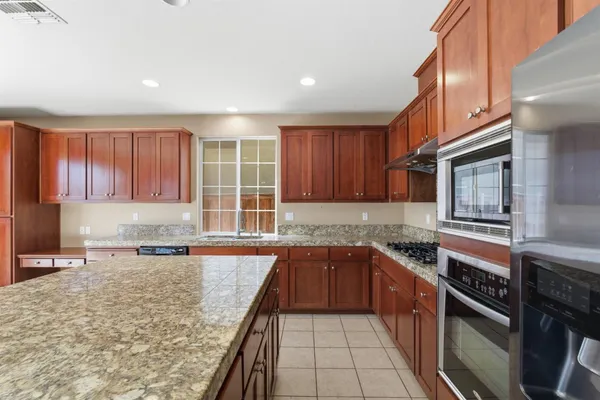 a kitchen with stainless steel appliances granite countertop a sink stove and cabinets
