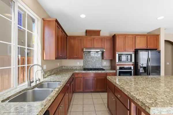a kitchen with granite countertop a stove and a sink