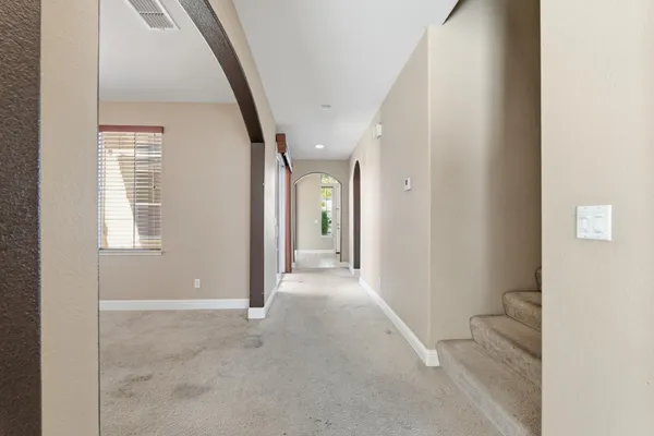 a view of staircase with lots of frames on wall and a window