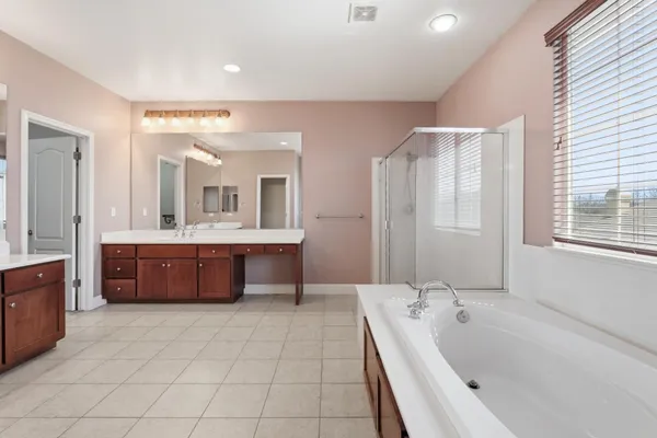 a bathroom with a sink toilet double vanity and tub