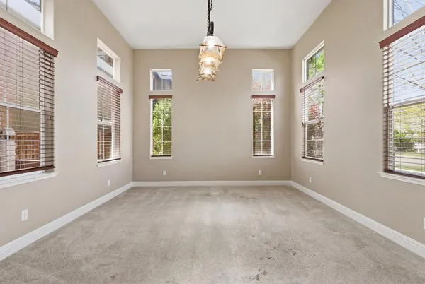 a view of an empty room with a fireplace and a window