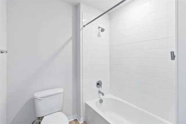a white toilet sitting next to a bath tub