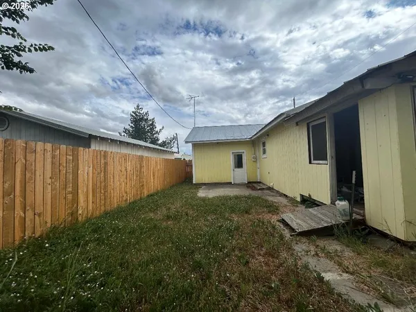 a view of a room with wooden floor and next to a window