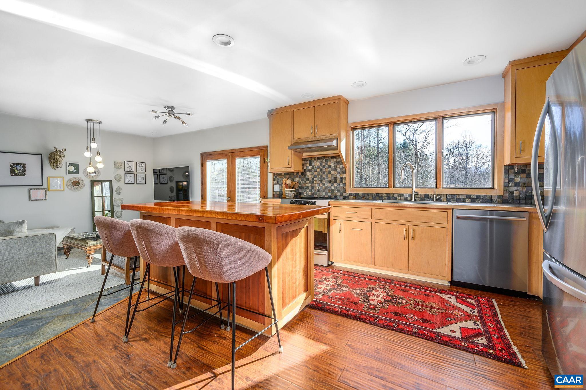 9663 Dyke Road Dyke, VA 22935 - Photo 6 of 55 a kitchen with stainless steel appliances granite countertop a stove a sink dishwasher and a dining table with wooden floor