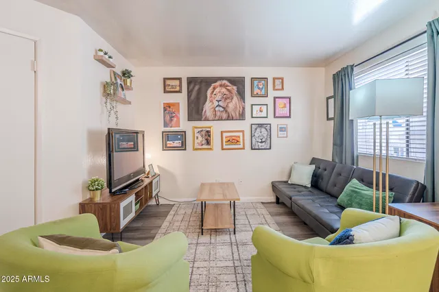 a living room with furniture a flat screen tv and a floor to ceiling window