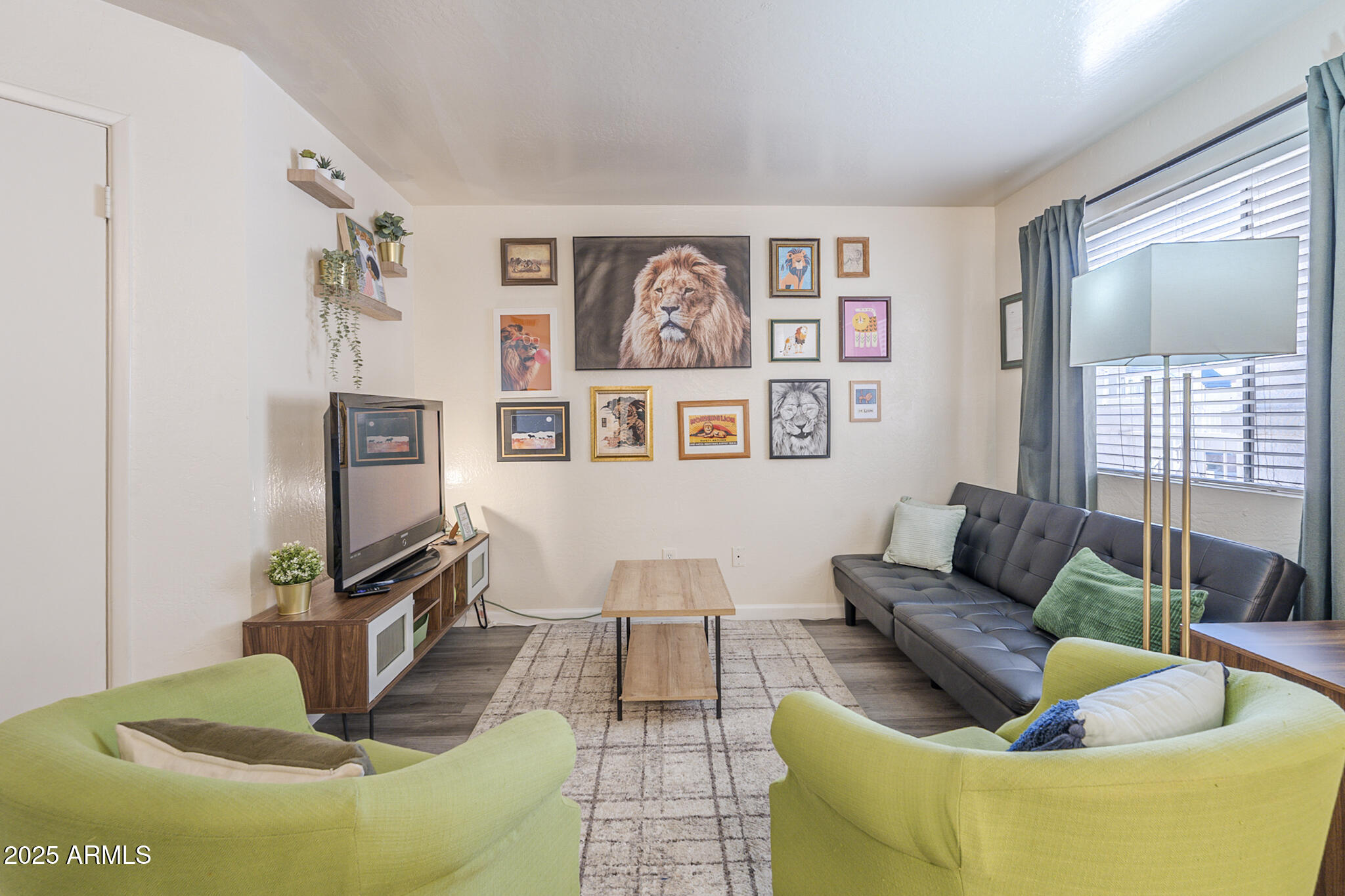 a living room with furniture a flat screen tv and a floor to ceiling window