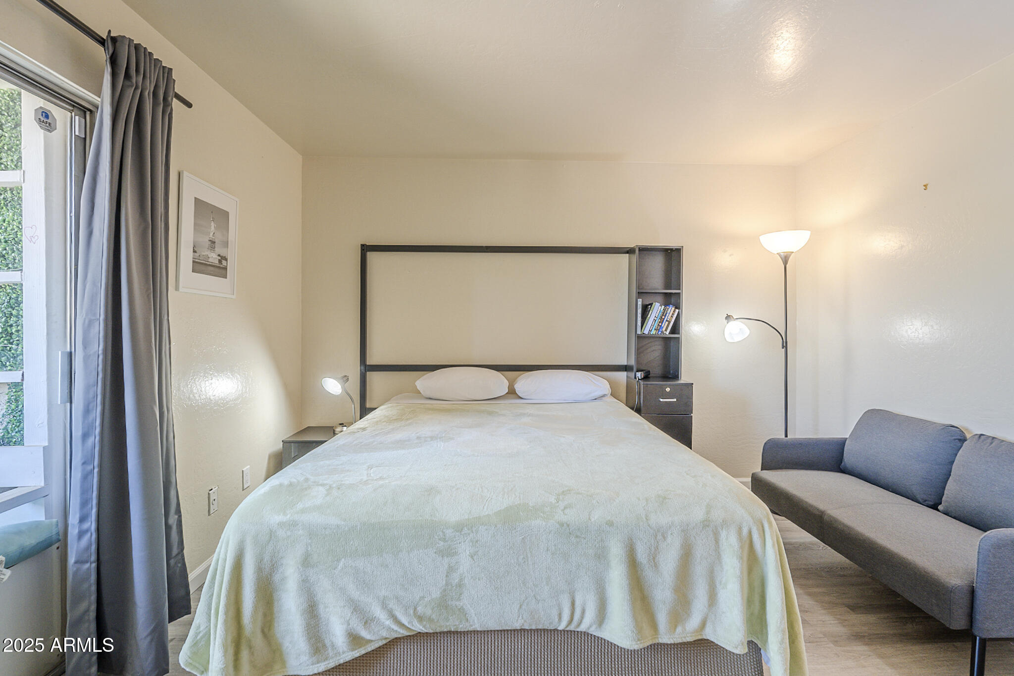 12123 West Bell Road, Unit 260 Surprise, AZ 85378 - Photo 18 of 29 a bedroom with a bed and a couch