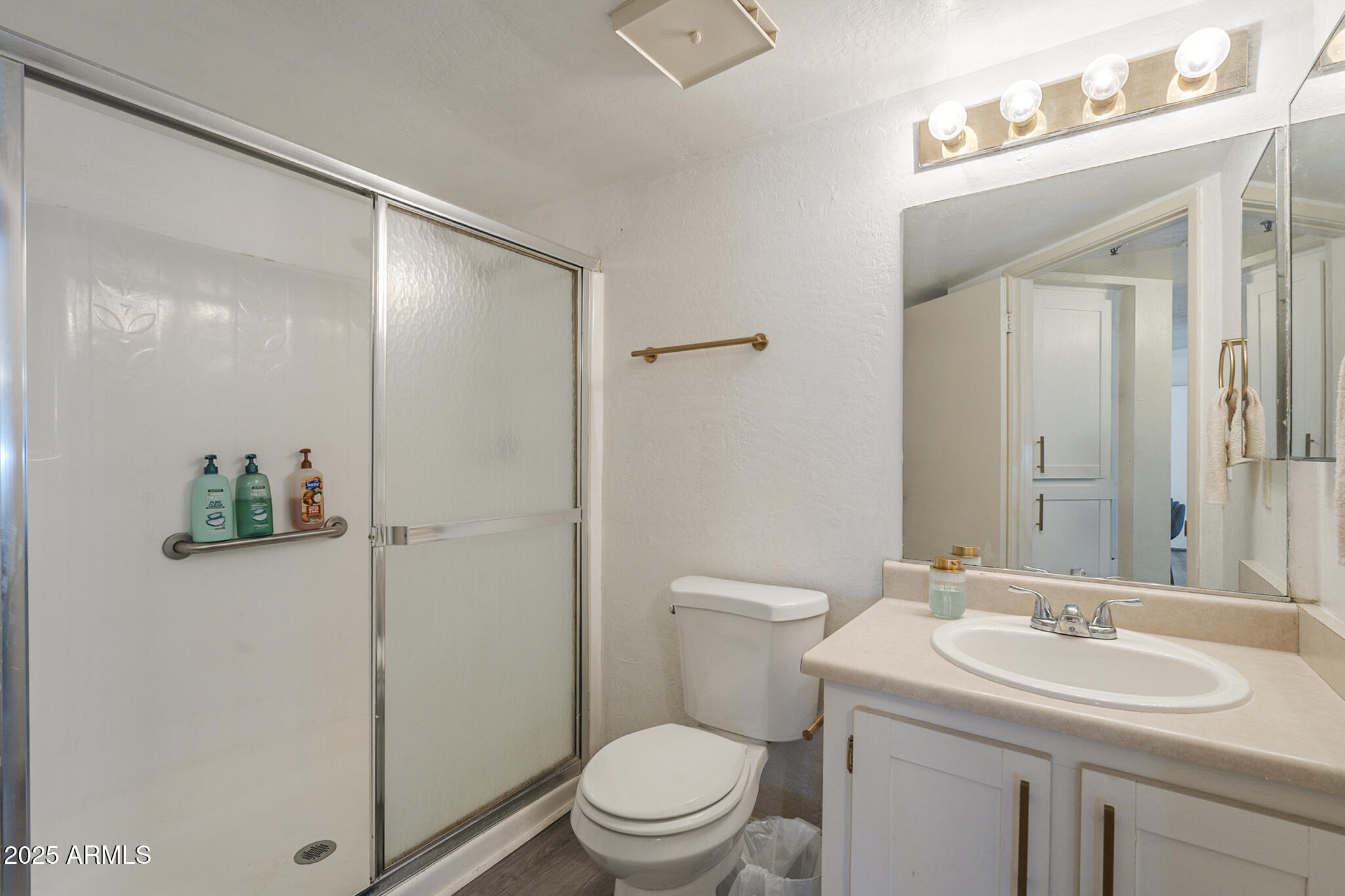 12123 West Bell Road, Unit 260 Surprise, AZ 85378 - Photo 20 of 29 a bathroom with a toilet a sink and a mirror