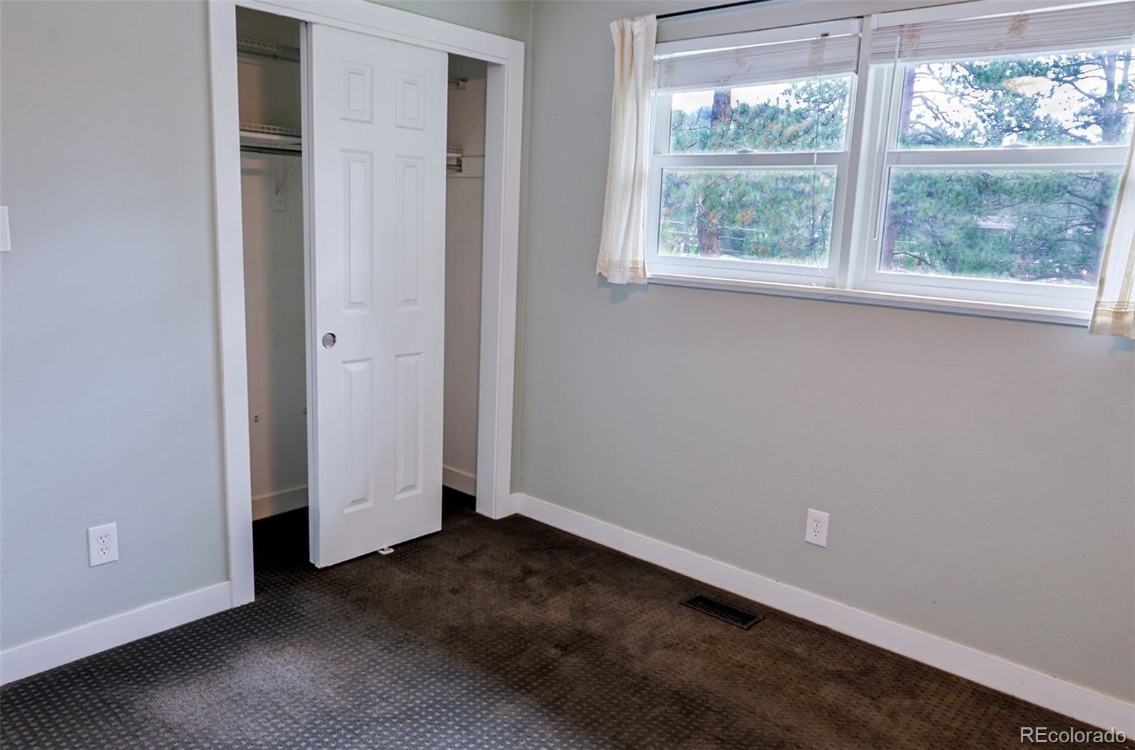 5237 South Olive Road Evergreen, CO 80439 - Photo 17 of 31 an empty room with wooden floor and windows