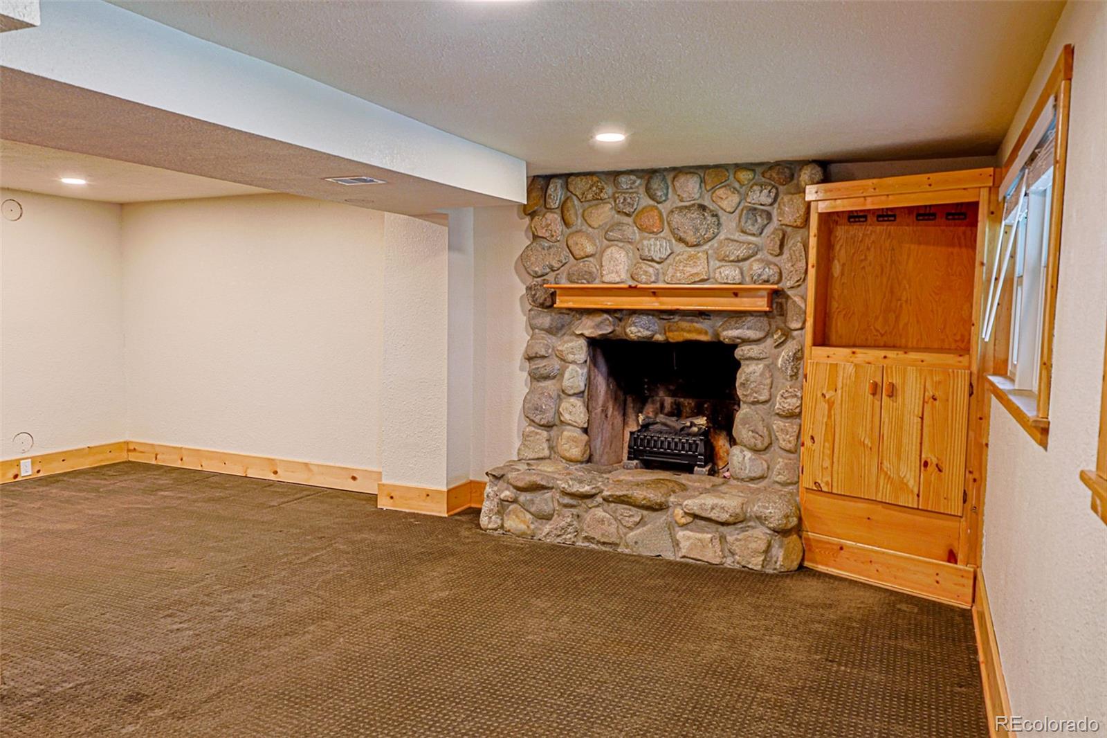 5237 South Olive Road Evergreen, CO 80439 - Photo 19 of 31 a view of an empty room and fire place