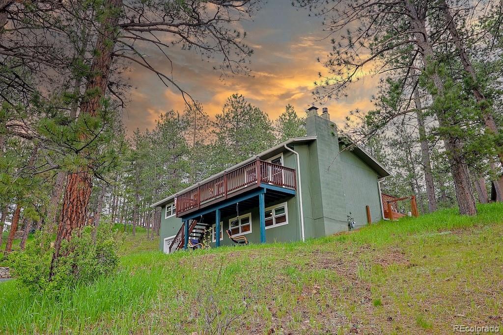 5237 South Olive Road Evergreen, CO 80439 - Photo 3 of 31 a backyard of a house with table and chairs