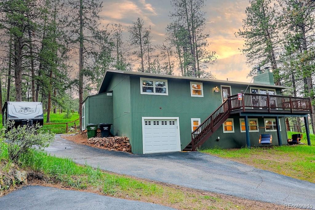 5237 South Olive Road Evergreen, CO 80439 - Photo 4 of 31 a front view of a house with a yard and table and chairs