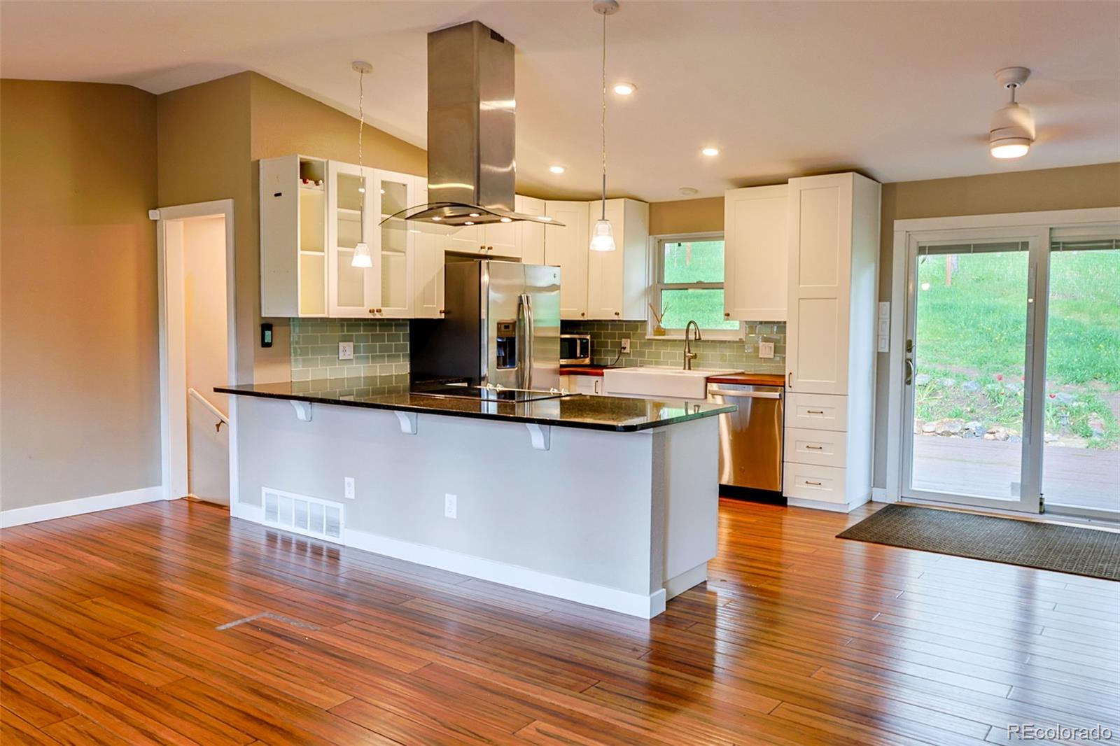 5237 South Olive Road Evergreen, CO 80439 - Photo 7 of 31 a kitchen with kitchen island granite countertop a sink cabinets and wooden floor