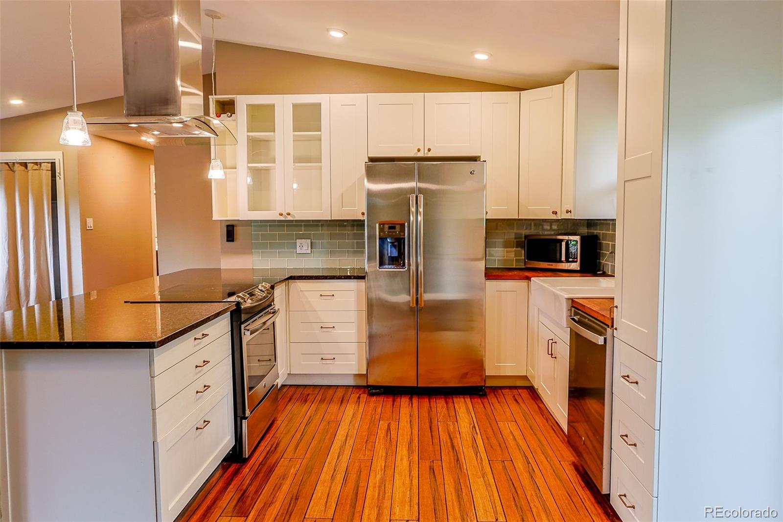 5237 South Olive Road Evergreen, CO 80439 - Photo 9 of 31 a kitchen with cabinets and wooden floor