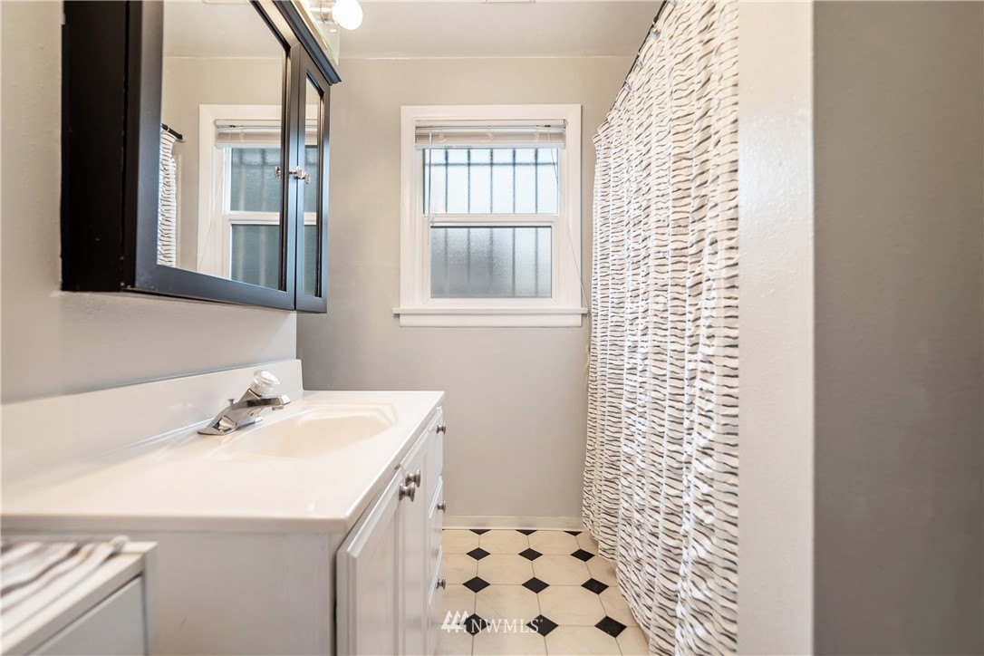 8216 Custer Road Southwest Lakewood, WA 98499 - Photo 11 of 20 a bathroom with a sink a mirror and shower