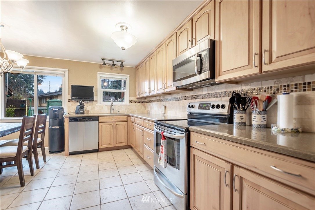 8216 Custer Road Southwest Lakewood, WA 98499 - Photo 5 of 20 a kitchen with stainless steel appliances granite countertop a sink and cabinets