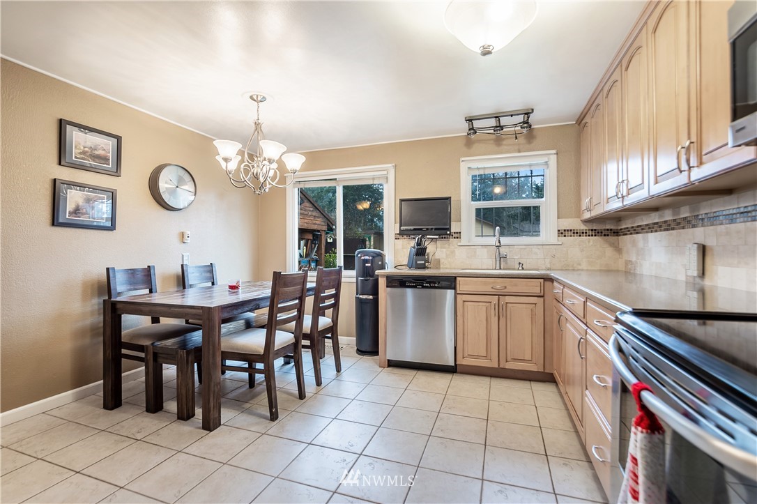 8216 Custer Road Southwest Lakewood, WA 98499 - Photo 6 of 20 a kitchen with a sink a counter and chairs