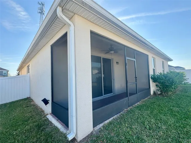 a view of backyard with potted plants and wooden fence