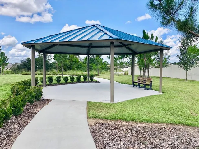 a view of a patio with a table and chairs under an umbrella
