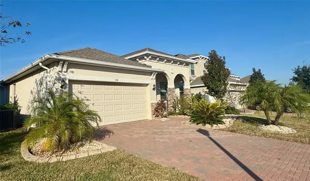 a view of a house with a small yard and potted plants