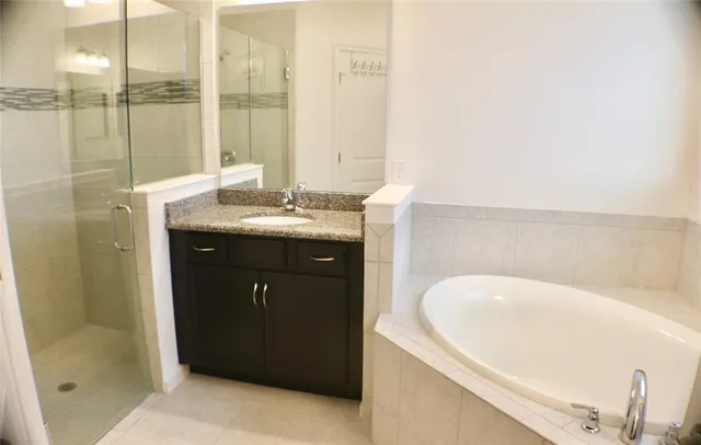 a bathroom with a tub sink and mirror