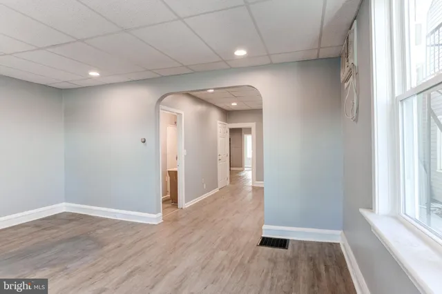 a view of hallway with a large window and wooden floor