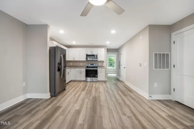 a view of kitchen with refrigerator microwave and stove top oven