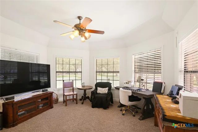 a living room with furniture a flat screen tv and a window