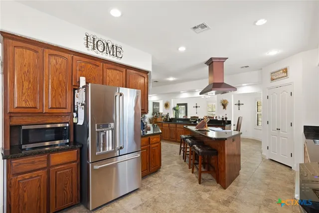 a kitchen with stainless steel appliances a refrigerator a stove a sink and a microwave