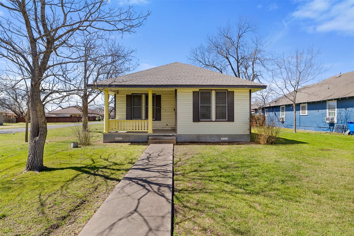 303 Vernon Street Taylor, TX 76574 - Photo 2 of 37 Bungalow-style home with covered porch, crawl space, a front lawn, and roof with shingles
