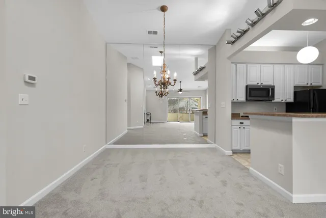 a view of a kitchen with a sink and dishwasher a stove top oven with wooden floor