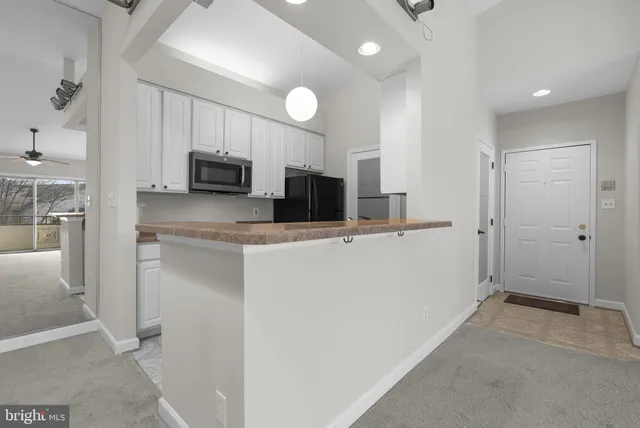 a kitchen with kitchen island granite countertop a sink cabinets and stainless steel appliances