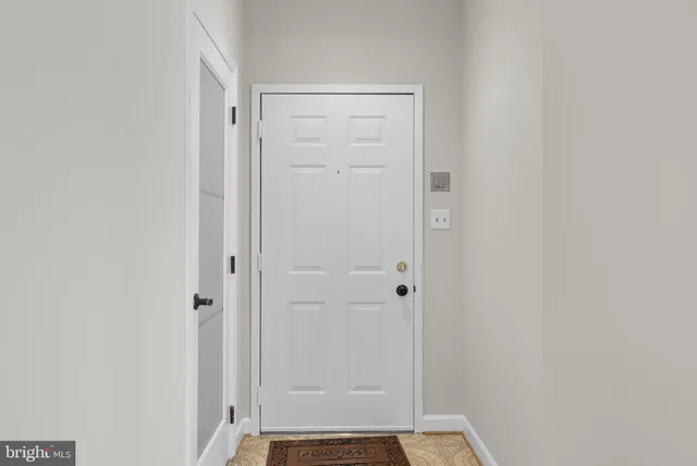 a view of an empty room with a fireplace and a window