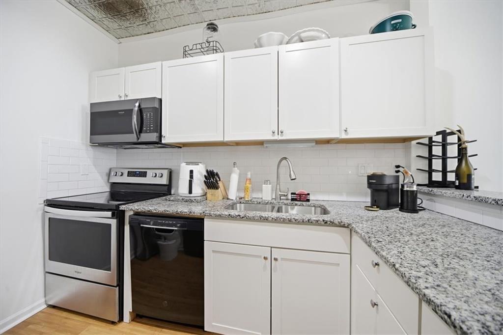 2215 Spring Walk Court Atlanta, GA 30341 - Photo 12 of 29 a kitchen with granite countertop a sink stainless steel appliances and white cabinets