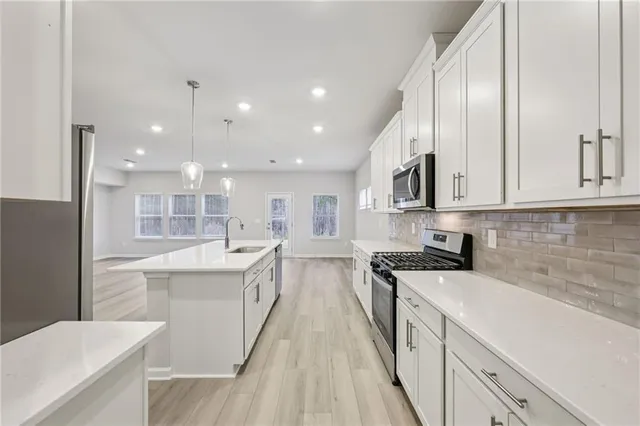 a large kitchen with stainless steel appliances lots of counter space and a sink