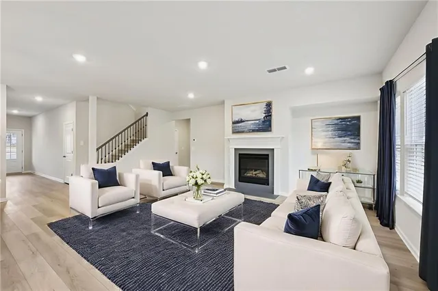 a view of kitchen with kitchen island wooden floors granite counter tops and white appliances