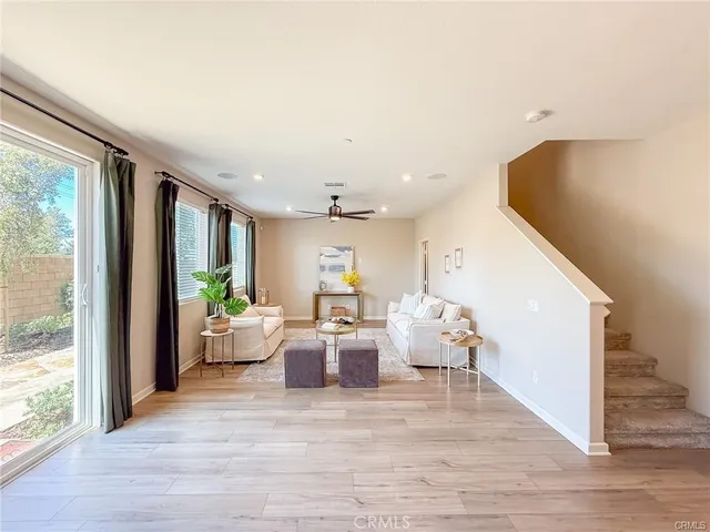 a living room with fireplace furniture and a large window