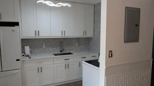 a kitchen with white cabinets and white appliances