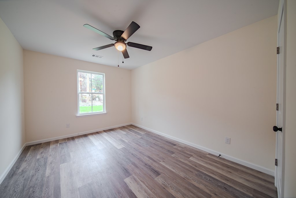 4396 Forrest Road Columbus, GA 31907 - Photo 21 of 24 an empty room with wooden floor a ceiling fan and windows
