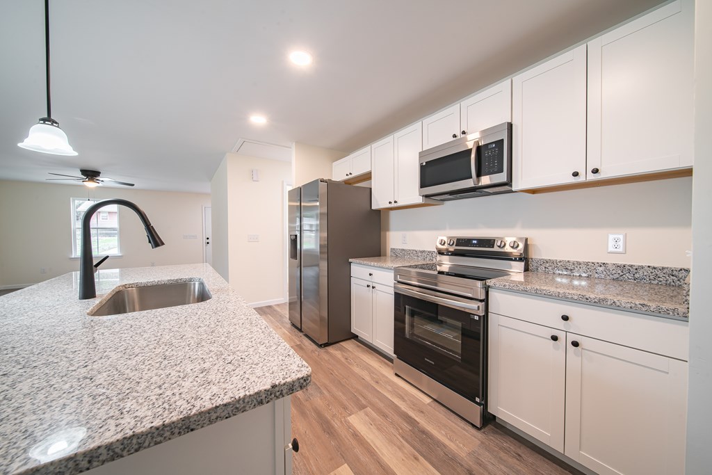 4396 Forrest Road Columbus, GA 31907 - Photo 10 of 24 a kitchen with stainless steel appliances granite countertop a sink stove and refrigerator