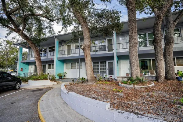 a front view of a building with trees around