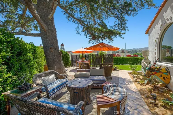 an outdoor sitting area with furniture and a garden