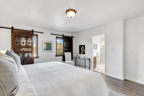 a bedroom with a bed and dresser with mirror