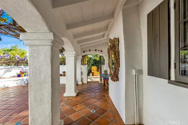 a view of a hallway with wooden floor and living room