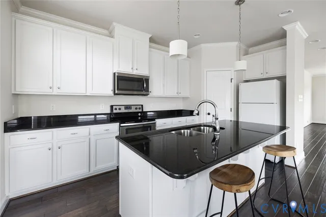 a close view of a refrigerator in kitchen with stainless steel appliances wooden floor