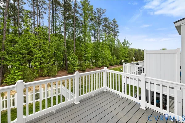 a view of a deck with wooden floor and fence with a garden