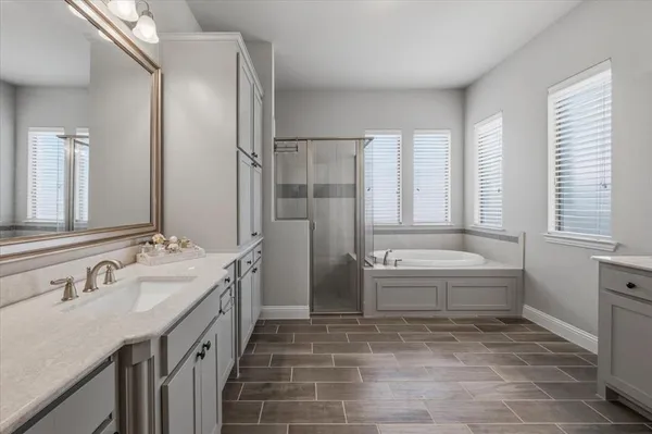 a bathroom with a tub sink and mirror